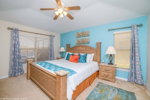 A bedroom with a wooden bed, two bedside tables, a ceiling fan, and patterned curtains. - Best Lake View in the Resort! CDC Cleaning Standards, Peaceful Location. #4av223 (Davenport)