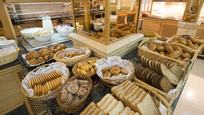 A buffet with various breads, pastries, and a milk dispenser. - Hotel Venecia Paguera (Calvia)
