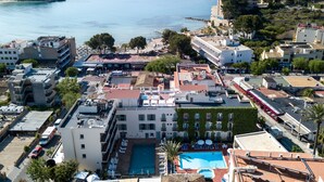 A hotel with a rooftop pool, multiple floors, and a view of the sea. - Hotel Venecia Paguera (Calvia)