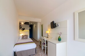 A hotel room with a bed, desk, chair, and a small table with a vase. - Hotel Venecia Paguera (Calvia)