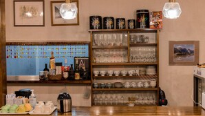 A bar area with shelves of glassware and coffee containers, a coffee machine, and a display of colorful cups. - Hotel Hakuba Powder Republic (Hakuba)