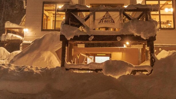A building with a snow-covered entrance and a sign that reads "Powder Republic." - Hotel Hakuba Powder Republic (Hakuba)