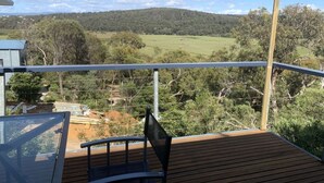 Une terrasse offrant une vue sur un paysage rural, avec des champs et des collines.