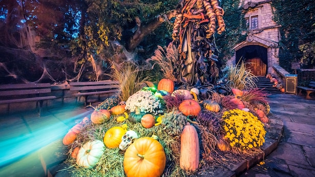 Une décoration sur le thème d’Halloween, avec des citrouilles et une statue d’épouvantail.