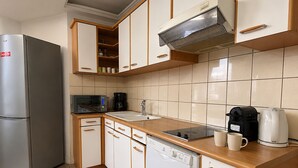 A compact kitchen with a refrigerator, microwave, coffee maker, and dishwasher. - L'appartement des Champs Elysées (Paris)