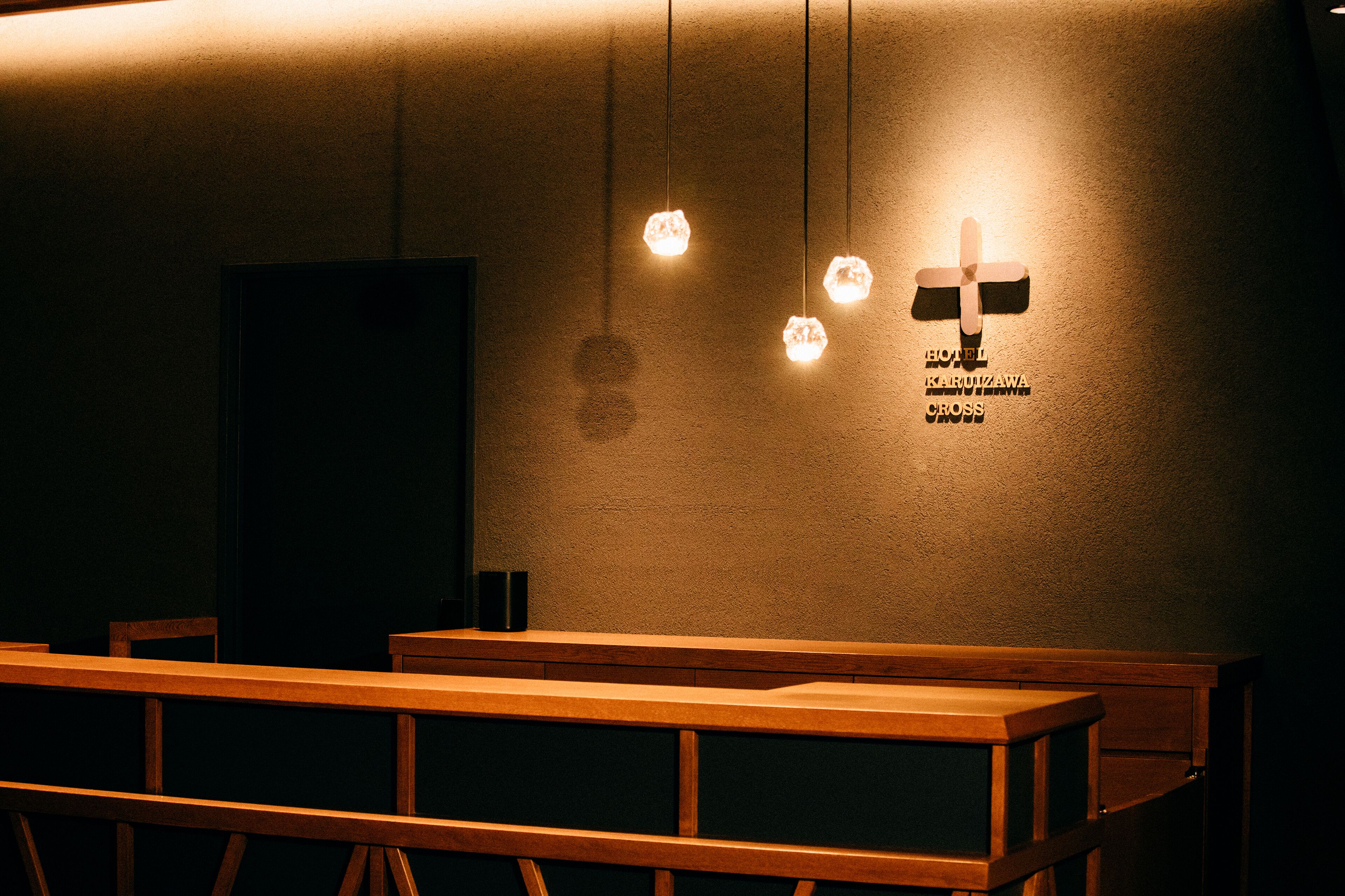 Une pièce avec des bancs en bois et un symbole en forme de croix fixé au mur.