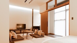 A modern hotel room with a large bed, a sofa, a small table, and a TV. - Hotel Karuizawa Cross (Karuizawa)