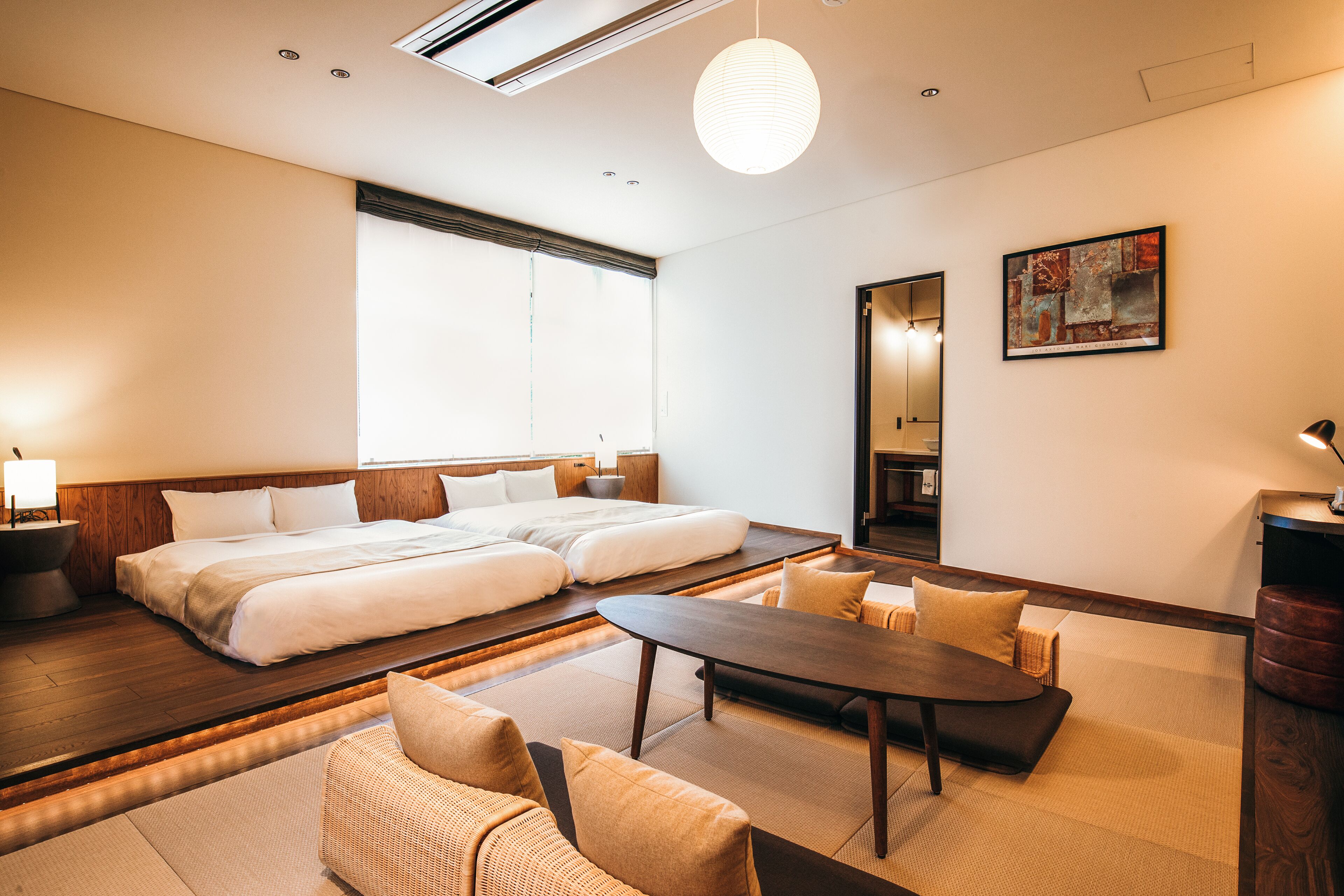 A hotel room with a large bed, a dining table, and a sofa.