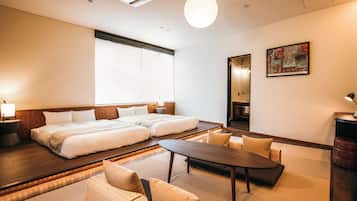 A hotel room with a large bed, a dining table, and a sofa.