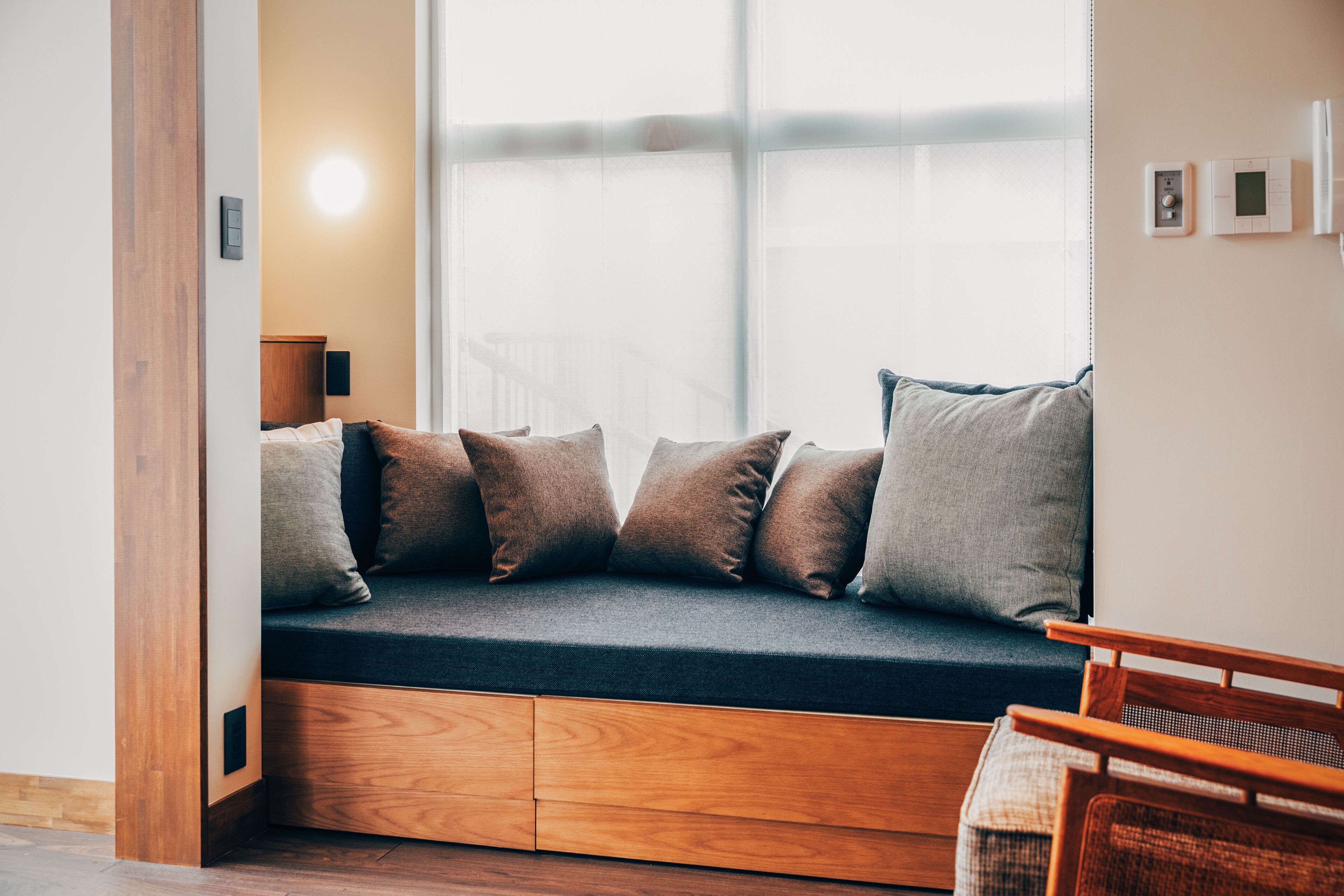A cozy seating area with a built-in bench, cushioned pillows, and a wooden side table.