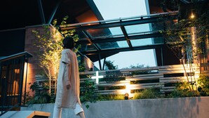A person walking on outdoor steps in front of a building with a cross sign, indicating a religious or historical site. - Hotel Karuizawa Cross (Karuizawa)