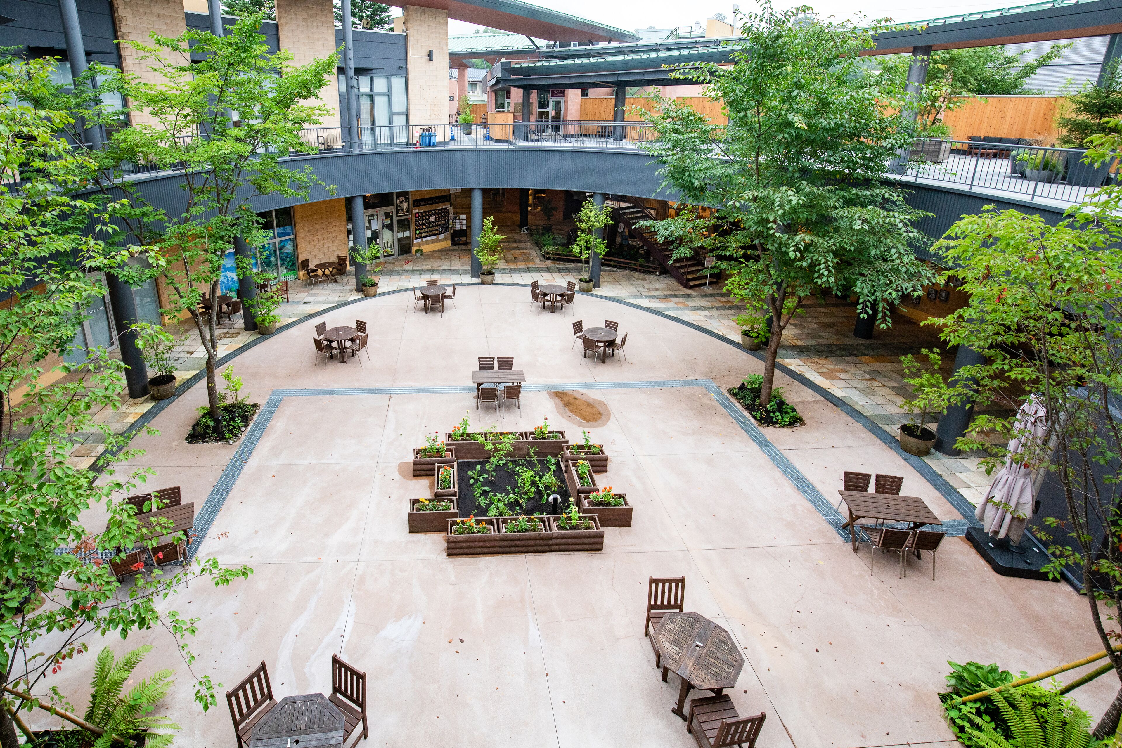 A spacious courtyard with multiple seating areas, a central garden, and a covered walkway.