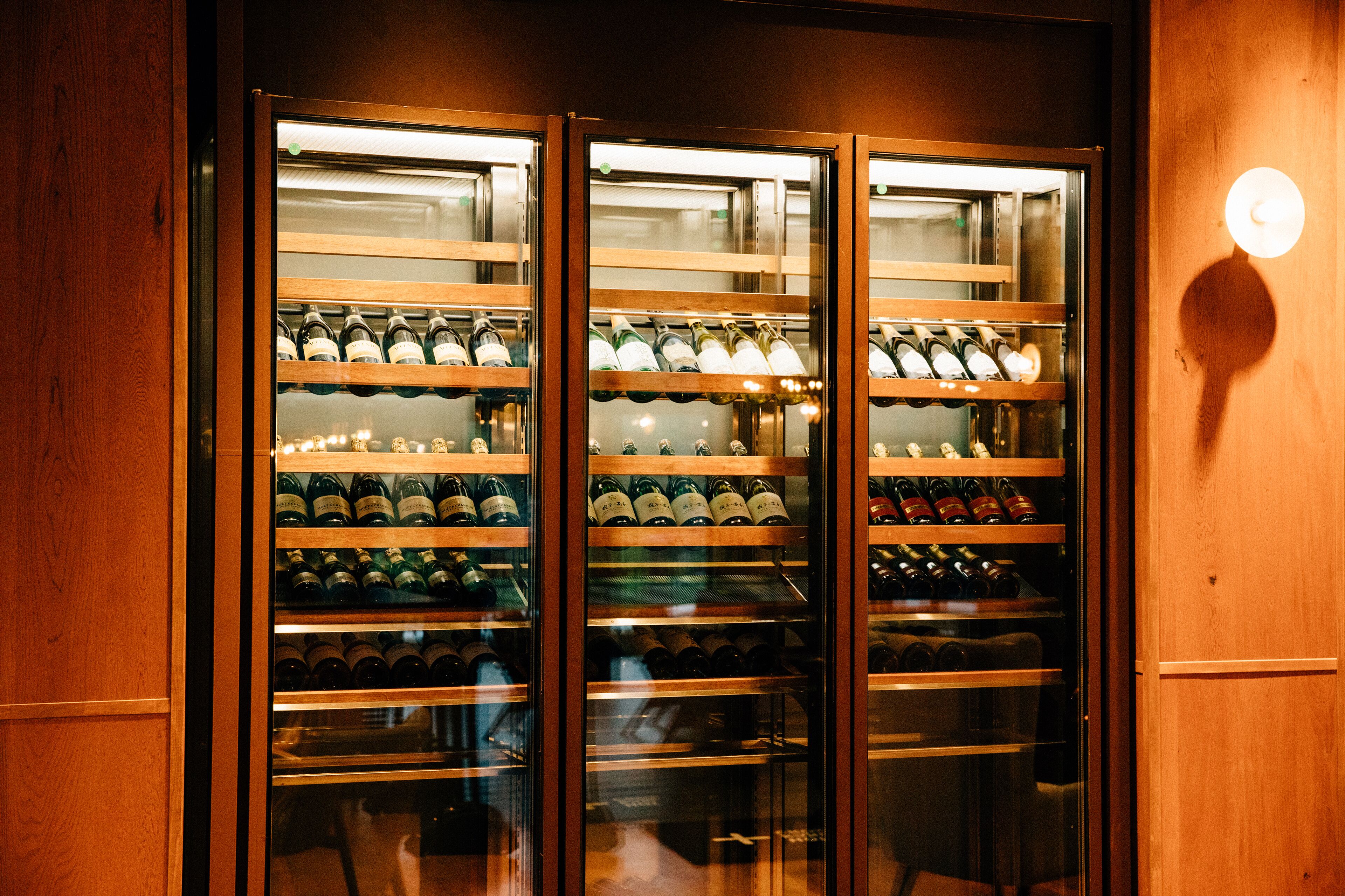 Un refrigerador para vino con varias estanterías llenas de botellas.