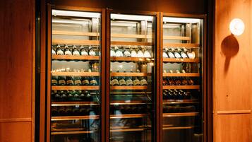 Un refrigerador para vino con varias estanterías llenas de botellas.