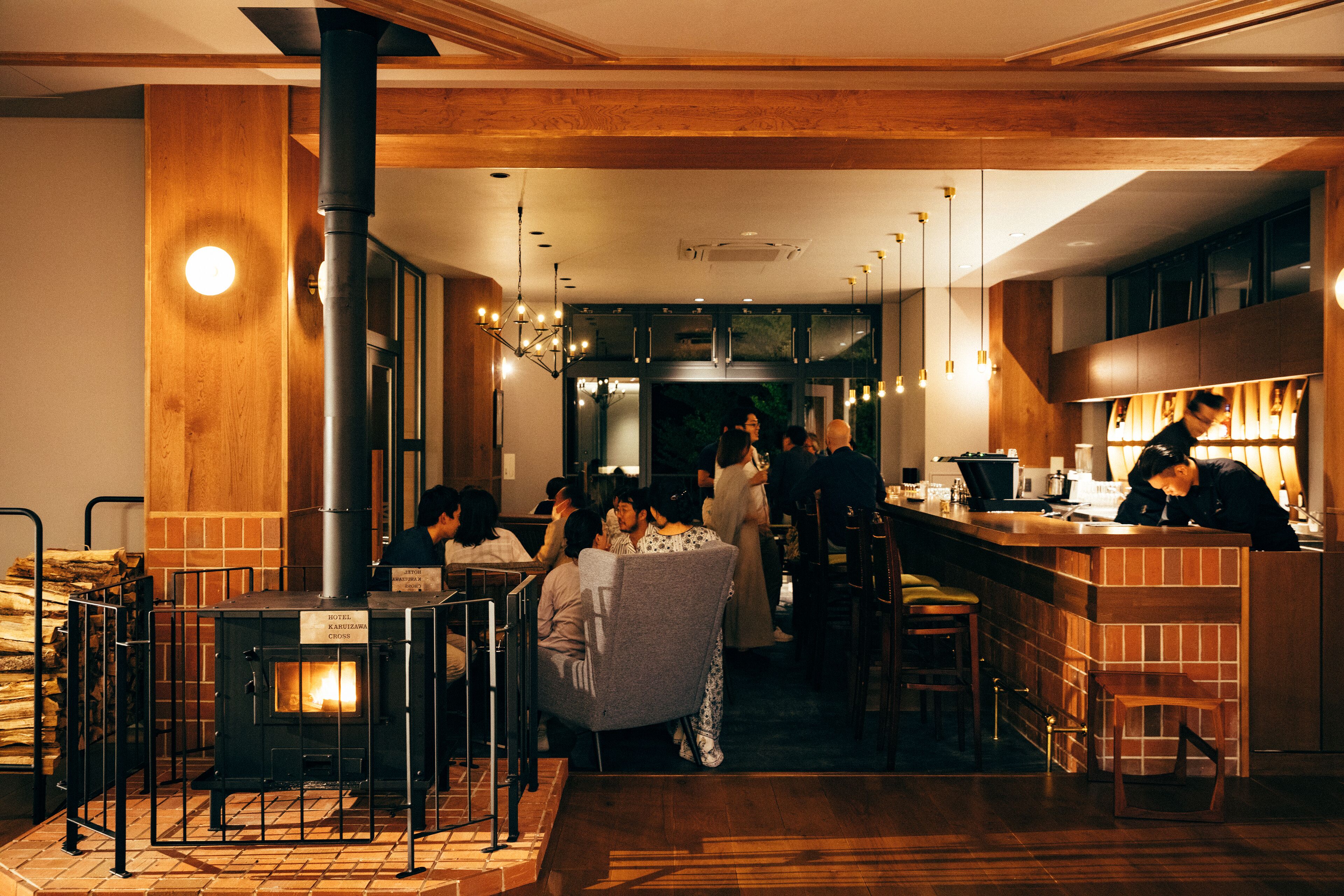 Un restaurant chaleureux avec un poêle à bois, des coins salon et un bar.