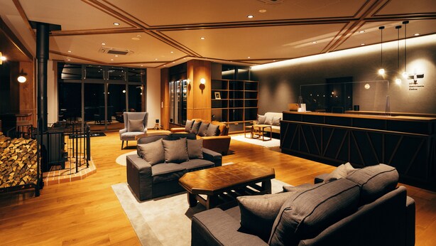 A modern interior with a wooden floor, sofas, a coffee table, and a bar area. - Hotel Karuizawa Cross (Karuizawa)