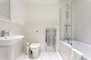 A modern bathroom with a white sink, toilet, and bathtub. - Modern 1 Bedroom Apartment Near Canary Wharf With Balcony (London)