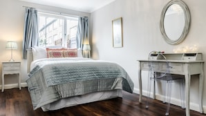 A bedroom with a bed, a dresser, a mirror, and a window with curtains. - Lovely 2 Bedroom Apartment With Garden, South Bank Westminster (London)