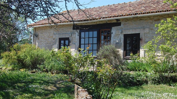 A stone house with a tiled roof, two windows, and a stone wall in front. - Peaceful Detached Cottage Studio French Countryside Private Garden Nature Lovers (champagne mouton)
