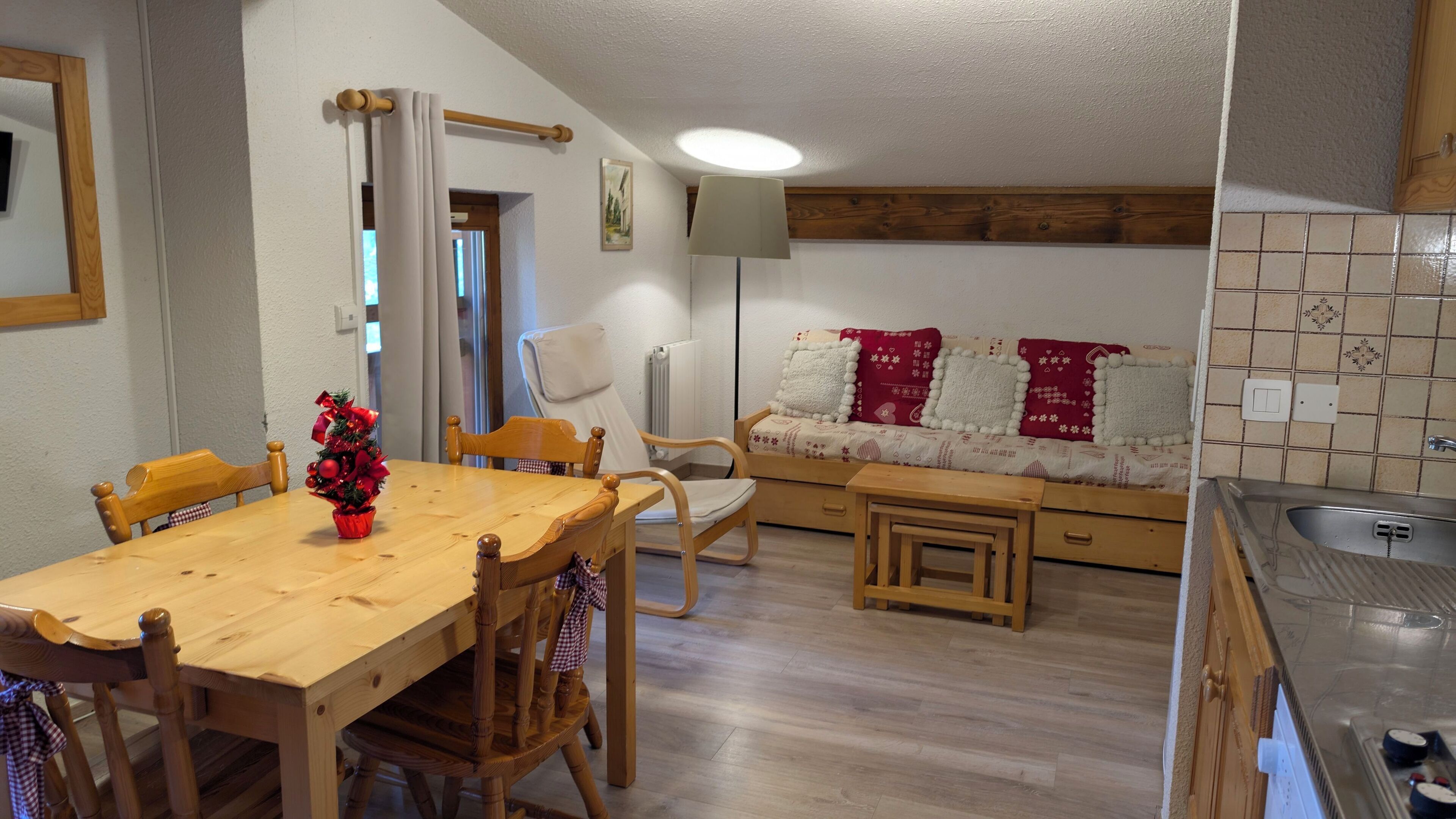 Een gezellige keuken met houten meubels, een eettafel en een kleine kitchenette.