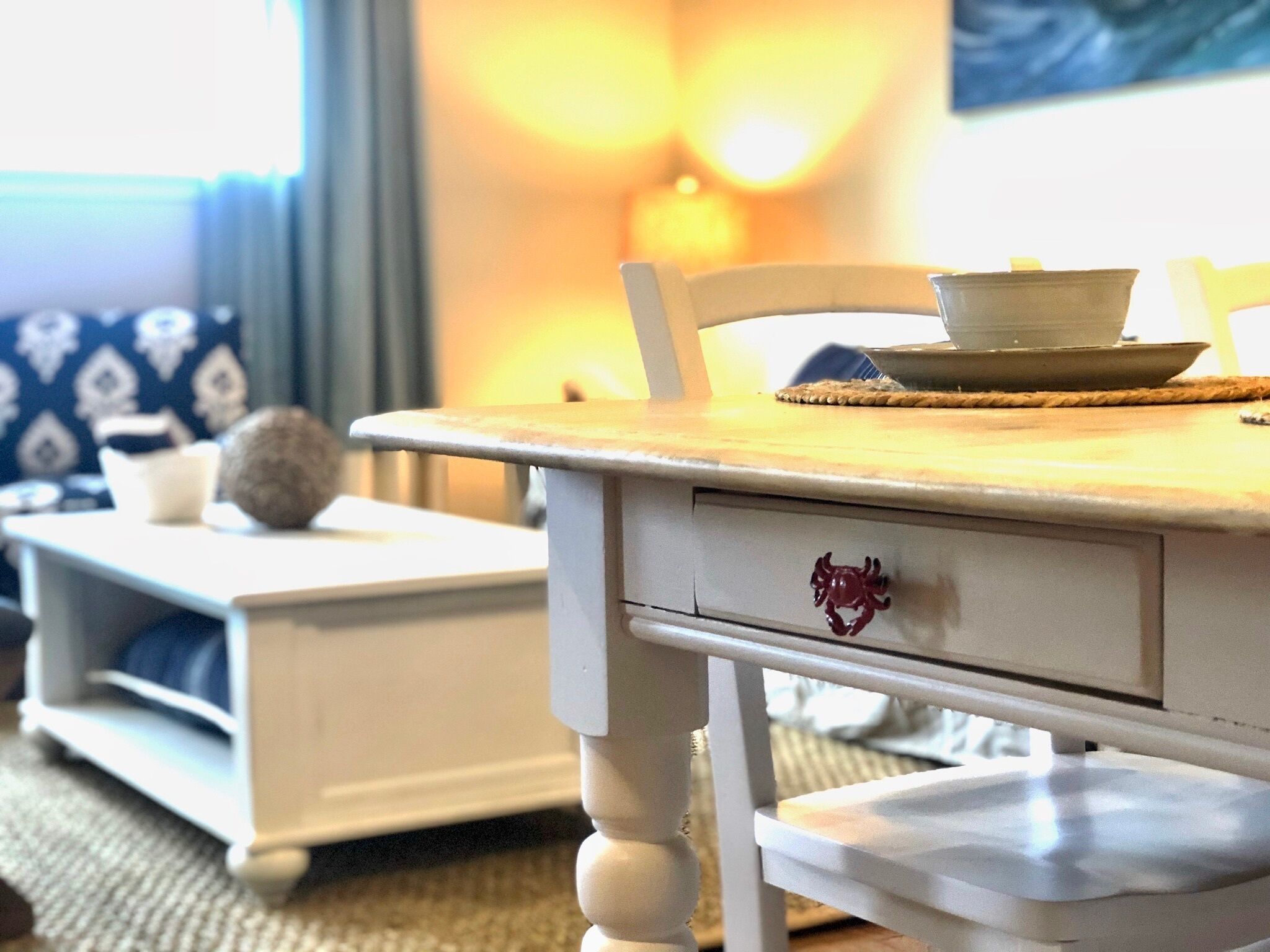 Een eetgedeelte met een houten tafel, een witte stoel en een bijzettafeltje met een kom en een bord.