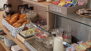 A breakfast buffet with various food items, including pastries, cereals, and dairy products. - Hotel Cosmos (Paris)