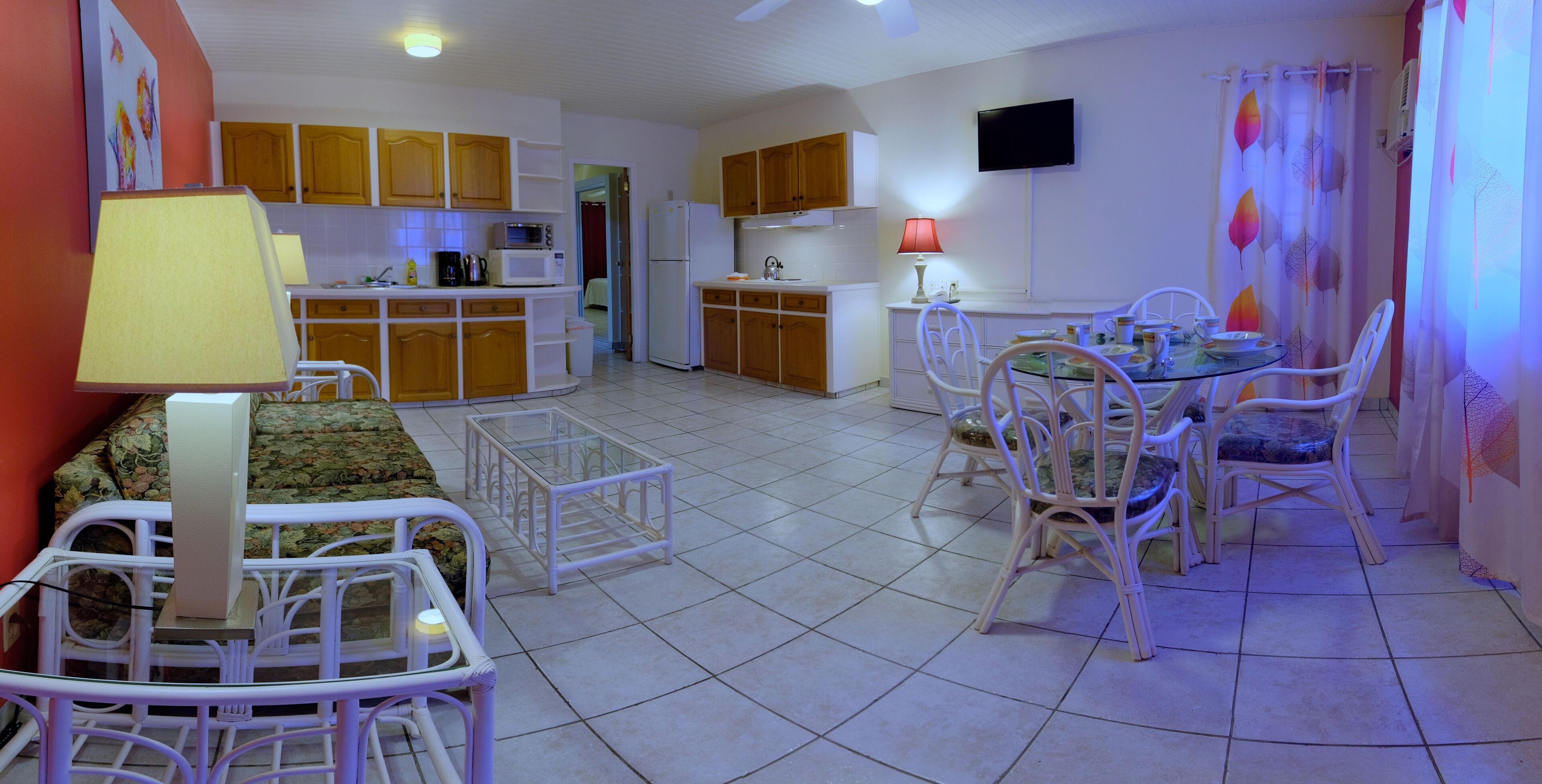 A compact living space with a kitchenette, dining area, and a sofa.