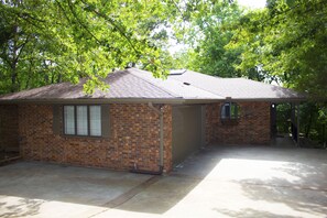 A single-story brick house with a sloped roof, a garage, and a covered porch area.