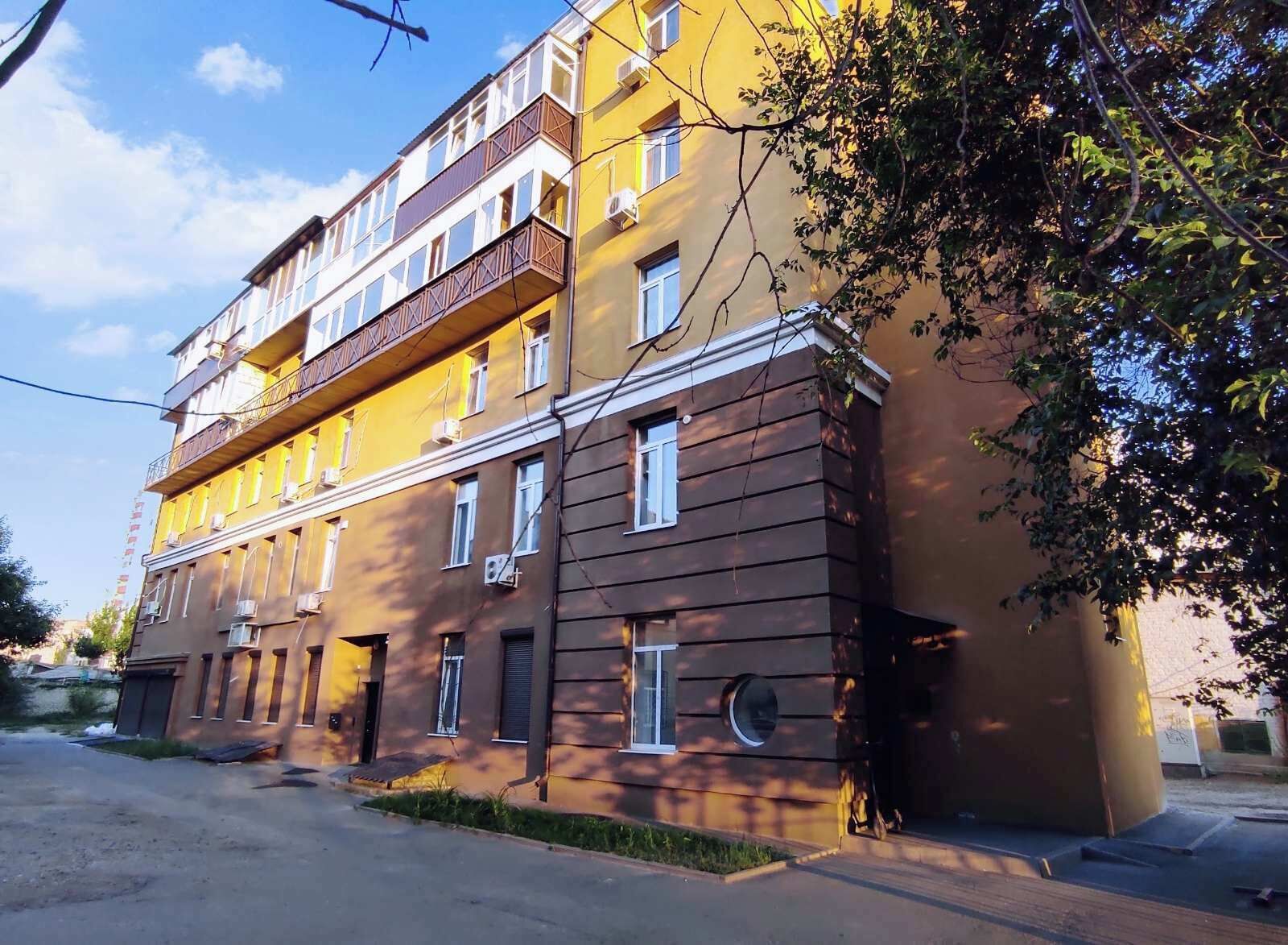 A multi-story building with balconies and air conditioning units.