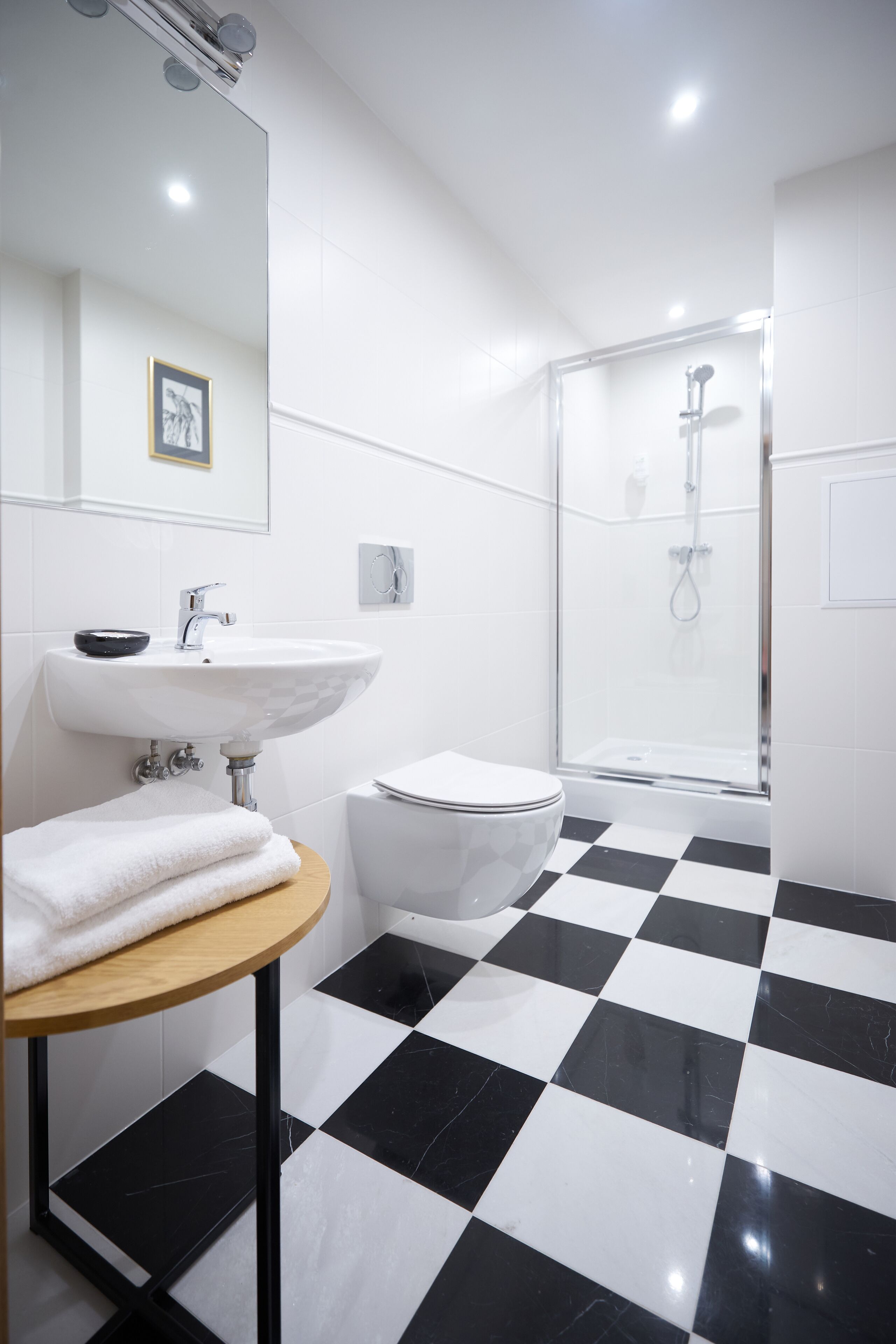 Un baño con piso a cuadros, un lavamanos, un inodoro y una ducha.