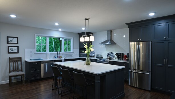 A modern kitchen with dark cabinetry, a central island, stainless steel appliances, and a large window providing natural light. - Top Location! 3D & Video Tour. Riverside 4/3 w/ the best water access & privacy! (Flippin)