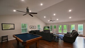A spacious living room with a pool table, a sofa, a recliner, and a ceiling fan. - Top Location! 3D & Video Tour. Riverside 4/3 w/ the best water access & privacy! (Flippin)