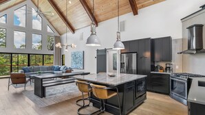 Una cocina amplia con electrodomésticos modernos, una isla grande y un comedor con sofá y sillas.