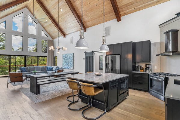 A spacious kitchen with modern appliances, a large island, and a dining area with a sofa and chairs.