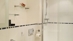 Ein Badezimmer mit Waschbecken, Toilette und einer Duschkabine.