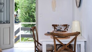 Un comedor con una mesa blanca, sillas de madera y un reloj en la pared.