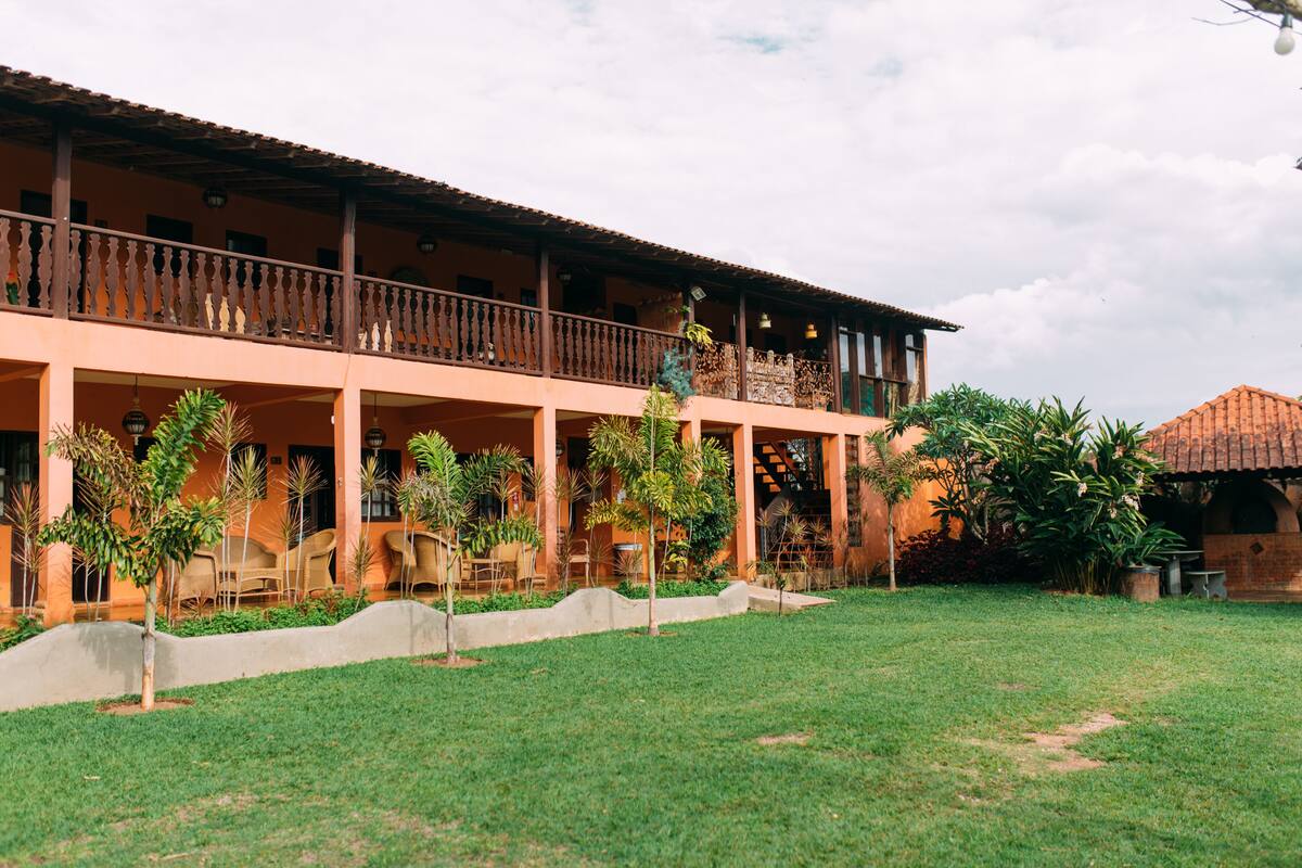 A hotel with a two-story structure, outdoor seating area, and a well-maintained lawn.