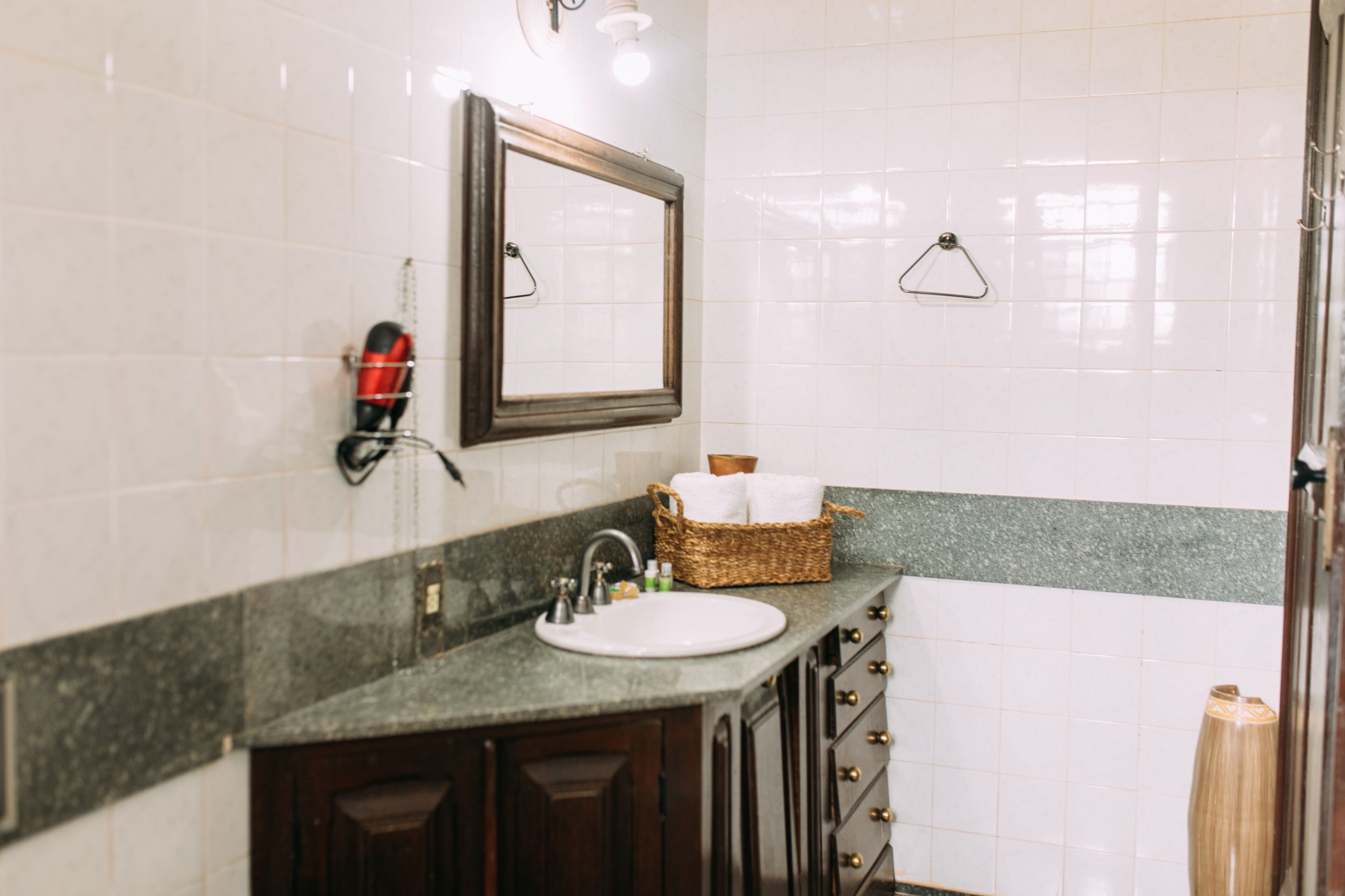 A bathroom with a sink, mirror, and towel rack.