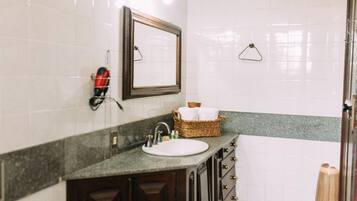 A bathroom with a sink, mirror, and towel rack.