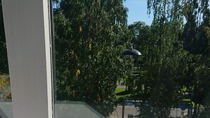 A window with a view of trees and a lamp post. - S12-3rd Floor Casa Grunerlokka (Oslo)