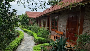 A stone pathway leading to a brick building with a tiled roof. - Tam Coc Melody Homestay (Nam Hoa Lu)