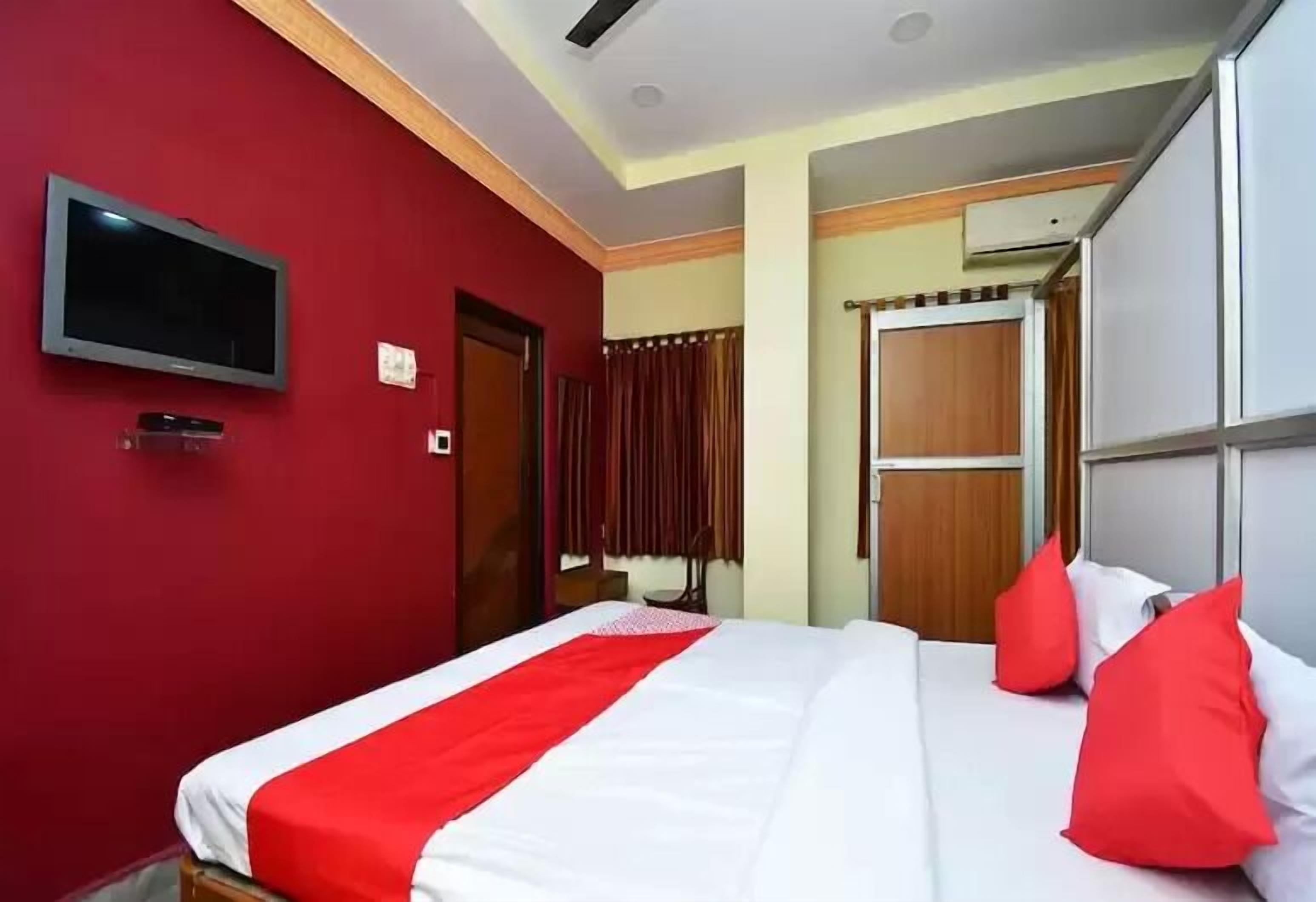 A hotel room with a bed, a television, and a wardrobe.