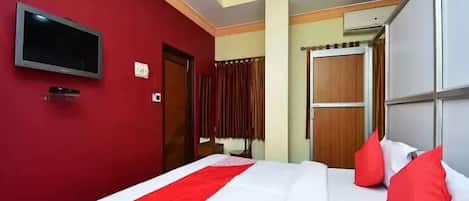 A hotel room with a bed, a television, and a wardrobe.