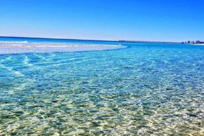 Ein freier Blick auf einen Strand mit einem Steg, der sich ins Meer erstreckt.