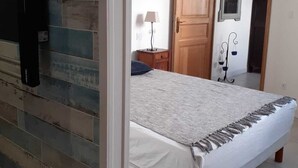 Una camera da letto con un letto, un comodino, una lampada, un armadio e uno specchio.