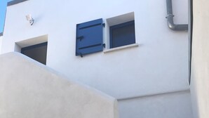 Un edificio bianco con una finestra blu e un portone bianco.