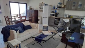 Un soggiorno con divano, tavolino, televisione e zona pranzo con tavolo e sedie.