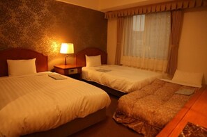 Two single beds with matching headboards and footboards, a wooden nightstand, and a desk with chair.