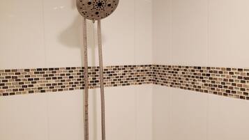 Een bad/douchecombinatie, een haardroger, handdoeken, zeep