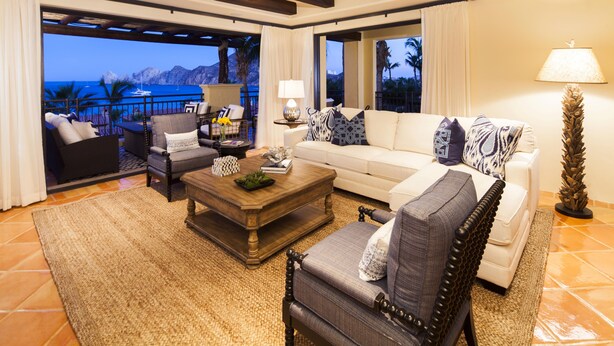 A spacious living room with a large sofa, armchairs, and a coffee table. There is a balcony with a view of the ocean and mountains. - Cabo Dream Stay-4BR Oceanview at Hacienda Beach Club can be rented as 2-3 bedrm (Cabo San Lucas)
